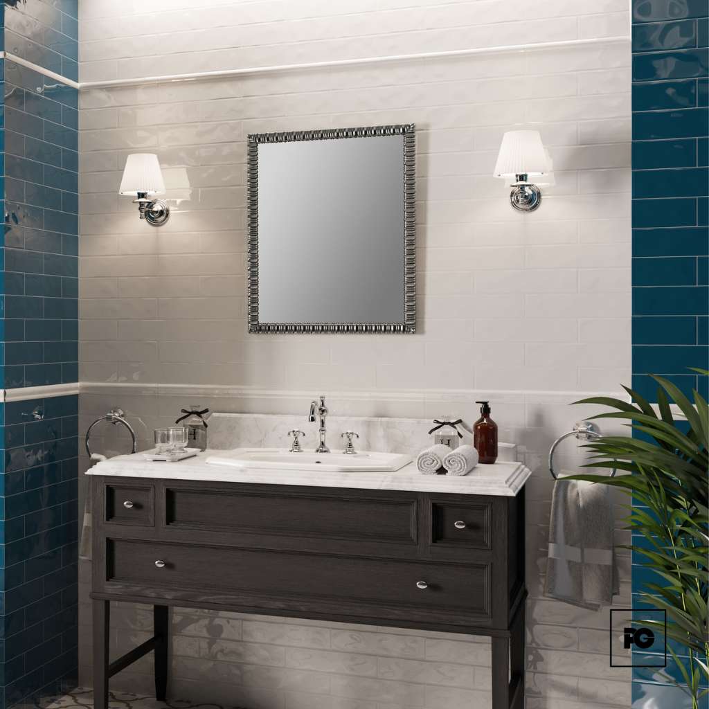Bathroom vanity with dark wood cabinet, white marble countertop, single sink, framed mirror, teal tiled walls, and two wall sconces.